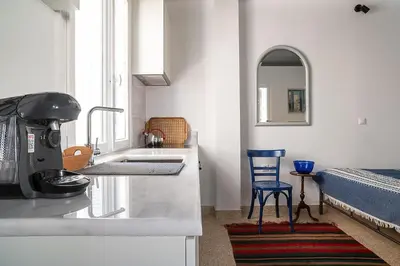 a kitchen with a sink and a blue chair at Athenian Cypress House, Studio in Athens