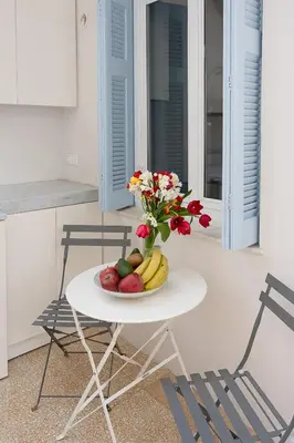 a table with a plate of fruit and flowers on it at Athenian Cypress House, Studio in Athens