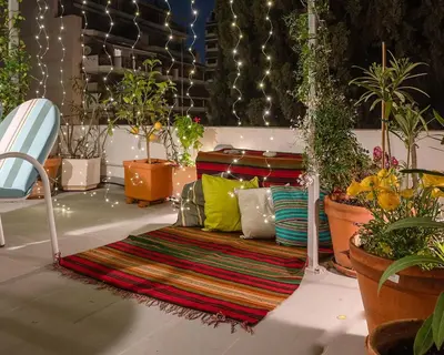 a couch with colorful pillows in a room with potted plants at Athenian Cypress House, Studio in Athens