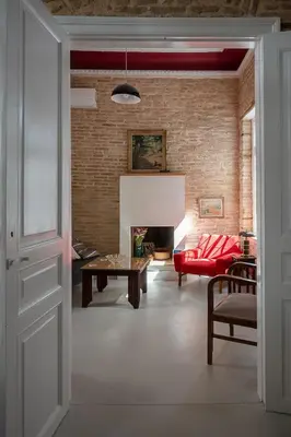 a living room with a red couch and a fireplace at Athenian Cypress House, Maisonette in Athens