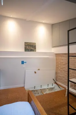 a room with a bed and a table and a shelf at Athenian Cypress House, Maisonette in Athens