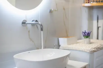 a white bathroom with a sink and a toilet at Elena's house in Athens