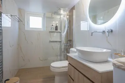 a bathroom with a sink and a toilet and a mirror at Elena's house in Athens