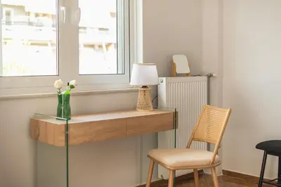 a desk with a vase of flowers and a chair at Elena's house in Athens