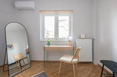 a room with a mirror and a desk and a window at Elena's house in Athens