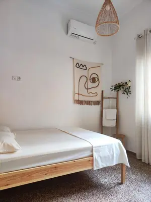 a bedroom with a bed with white sheets and a window at Casa Lula in Athens