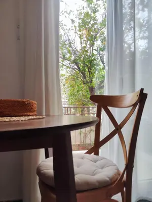 a wooden table and a chair next to a window at Casa Lula in Athens