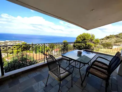 a patio with a table and chairs on a balcony at Peaceful Hilltop View Maisonette in Anavissos