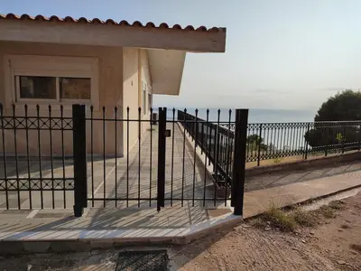 a iron fence in front of a house at Peaceful Hilltop View Maisonette in Anavissos