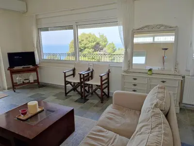 a living room with a couch and a table at Peaceful Hilltop View Maisonette in Anavissos