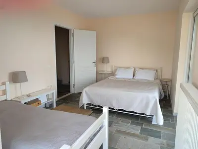 a white bedroom with two beds and two lamps at Peaceful Hilltop View Maisonette in Anavissos