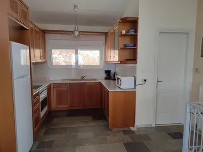 a kitchen with wooden cabinets and a white refrigerator at Peaceful Hilltop View Maisonette in Anavissos