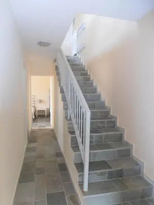 a staircase in a home with a white stair case at Peaceful Hilltop View Maisonette in Anavissos