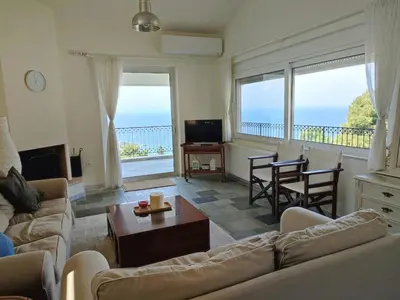 a living room with a view of the ocean at Peaceful Hilltop View Maisonette in Anavissos