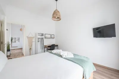 a white bedroom with a bed and a tv at Ble Elia Flat for two in Athens in Athens