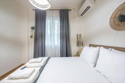 a bedroom with a white bed with white pillows and a window at Ble Elia Artemis Suite in Athens