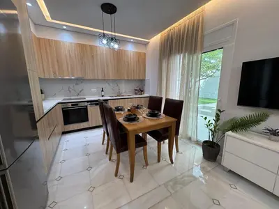 a kitchen with a table and chairs and a television at Caza pool Glyfada in Athens
