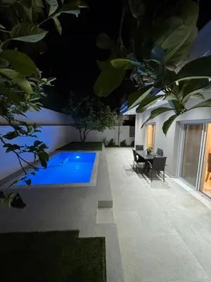 a swimming pool in the middle of a yard at night at Caza pool Glyfada in Athens