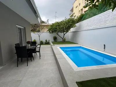 a backyard with a swimming pool and a table and chairs at Caza pool Glyfada in Athens