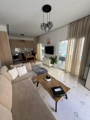 a living room with a couch and a table at Caza pool Glyfada in Athens