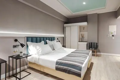 a bedroom with a large bed and a desk at Athens Cypria Hotel in Athens