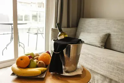a blender with a bottle of wine and fruit on a table at Athens Cypria Hotel in Athens