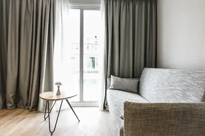a living room with a couch and a table and a window at Athens Cypria Hotel in Athens