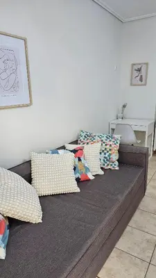 a couch with pillows on it in a room at Casa Geli l Comfort meets charm, centrally located in Athens