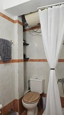 a bathroom with a toilet and a shower curtain at Casa Geli l Comfort meets charm, centrally located in Athens