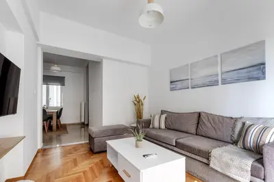 a living room with a couch and a table at Arco - Sleek 2-BR Apt in the Heart of Athens in Athens