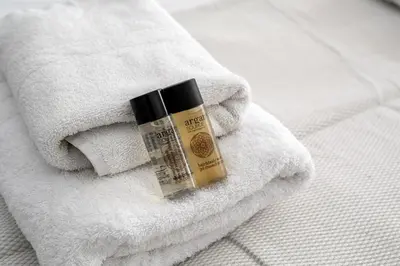 a bottle of sunscreen sitting on top of a towel at Arco - Sleek 2-BR Apt in the Heart of Athens in Athens