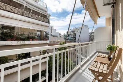 a balcony with a wooden table and a chair at Arco - Sleek 2-BR Apt in the Heart of Athens in Athens