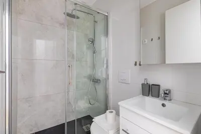 a bathroom with a shower and a toilet and a sink at Arco - Sleek 2-BR Apt in the Heart of Athens in Athens