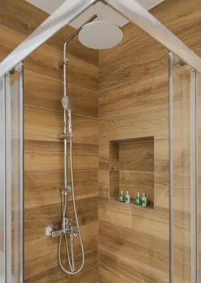 a shower in a bathroom with a wooden wall at Athens Luxury Ethereal View in Athens