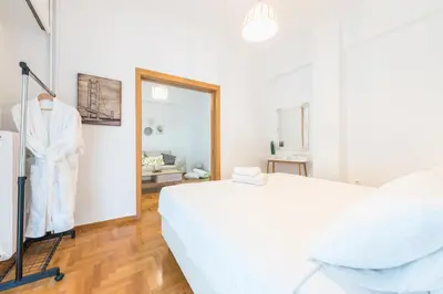 a white bedroom with a bed and a mirror at Ble Elia Acropolis 2bdr Suite in Athens