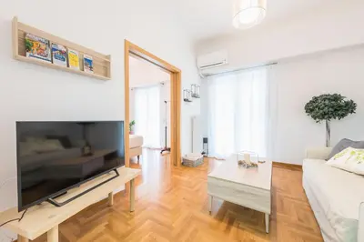 a living room with a large flat screen tv at Ble Elia Acropolis 2bdr Suite in Athens