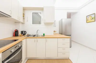 a white kitchen with a sink and a refrigerator at Ble Elia Acropolis 2bdr Suite in Athens