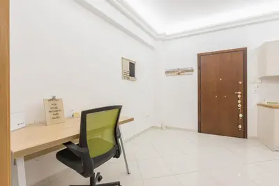 a office with a desk and a green chair at Ble Elia Acropolis 2bdr Suite in Athens