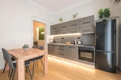 a kitchen with a wooden table and a stainless steel refrigerator at Platon At Philopappou By Greece Apartments in Athens