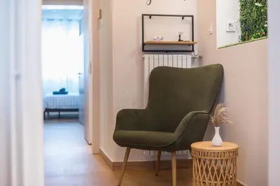 a green chair in a living room with a table at Platon At Philopappou By Greece Apartments in Athens
