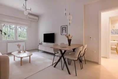 a white living room with a table and chairs at Minimal Luxury Apartments in Kolonaki by UPSTREET in Athens