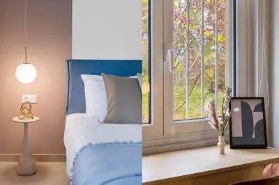 a bedroom with a blue bed and a window at Minimal Luxury Apartments in Kolonaki by UPSTREET in Athens