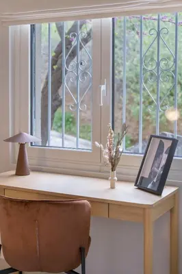 a desk with a picture on it next to a window at Minimal Luxury Apartments in Kolonaki by UPSTREET in Athens