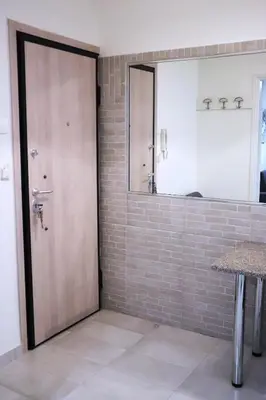 a bathroom with a wooden door and a mirror at Cozy Mirror Apartment in Athens