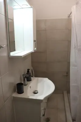 a bathroom with a sink and a mirror and a shower at Cozy Mirror Apartment in Athens