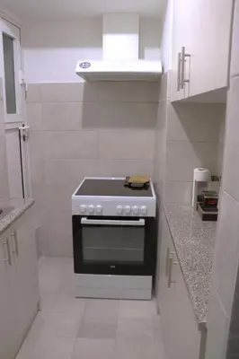 a white kitchen with a stove top oven at Cozy Mirror Apartment in Athens