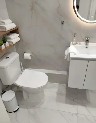 a white bathroom with a toilet and a sink at Amazing Apt with 2 Bedrooms in Pagkrati in Athens