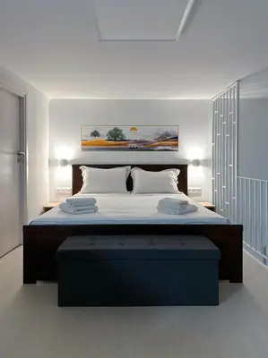 a bedroom with a large bed with a blue foot board at Glyfada Sea Breeze Loft A in Athens