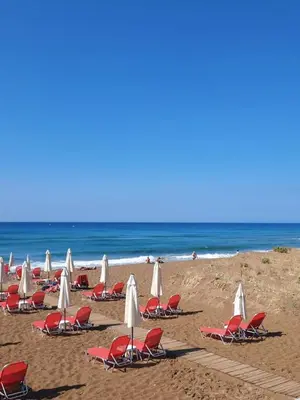 a group of chairs and umbrellas on a beach at Glyfada Sea Breeze Loft A in Athens