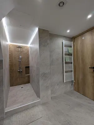 a bathroom with a shower with a glass wall at Moda home 3siblings in Athens